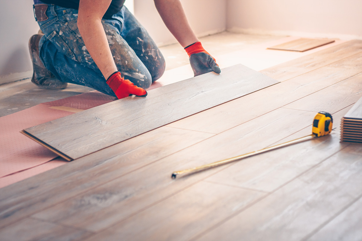 A person installing hardwood flooring in an El Paso home.
